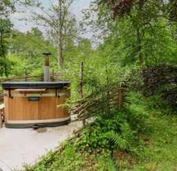 A hot tub surrounded by plants and a wooden fence at Bracken Fern in Eppleby
