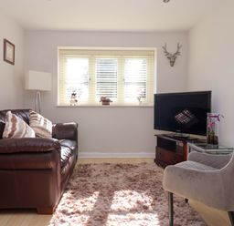 A living room with a sofa and television at Cartwheel Cottage in Yearsley