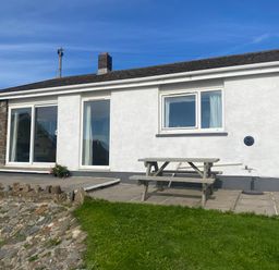 A house with a table on stone patio at Valley High in Solva