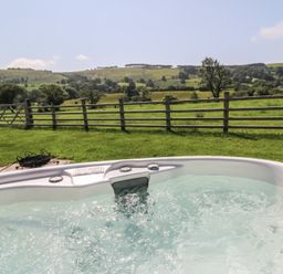 A hot tub with a view of the landscape at Bwthyn Bach Brefi