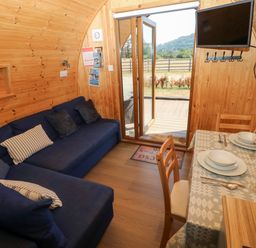 A living room with a sofa and a dining table at Bwthyn Bach Brefi in Llanddewi-Brefi