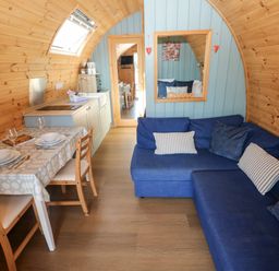 A living room with a couch and dining area at Bwthyn Bach Brefi in Llanddewi-Brefi