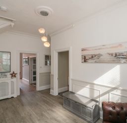 A hallway with a console table and wall art at Royal Victoria House in Scarborough