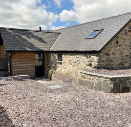 Stone cottage with slate roof and gravel yard at The Shippon in Llanrwst