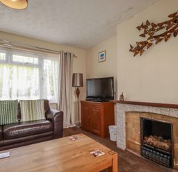 A living room with a sofa, television and coffee table at Underlanes in Boscastle