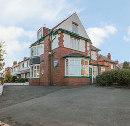 A residential street with red brick houses and driveways with parked cars and bushes at Hillcrest in Scarborough