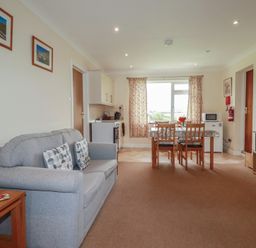 A living room with a sofa and dining area at Little Lanes in Boscastle