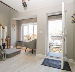 An entryway with an open door a chair umbrella stand and stairs at Bishop Fell in Newby Bridge