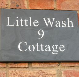 A house name plaque reading Little Wash 9 Cottage on a brick wall at Little Wash Cottage in Hunstanton
