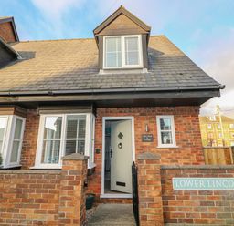 A brick house with a tiled roof and white windows on Lower Lincoln Street at Little Wash Cottage in Hunstanton
