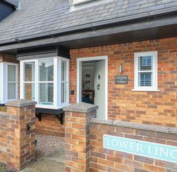 The front entrance of a brick house with a small garden area and a sign reading lower lincoln at Little Wash Cottage in Hunstanton