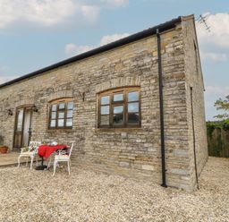 An outdoor seating area with a table and chairs at Bramble Cottage in Babcary near Lydford-On-Fosse