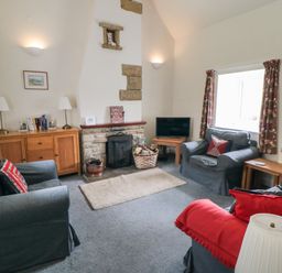 A sitting room with three armchairs a wooden sideboard and a TV on a small wooden table at Silver Birches in Glaisdale