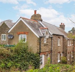 An exterior view of a house with a satellite dish at Yew Tree Cottage in Stoke Fleming