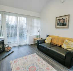 A living room with a sofa and wood stove at 2 Mountain View, Talwrn near Llangefni