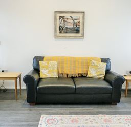 A living room with a sofa and side tables at 2 Mountain View in Talwrn near Llangefni