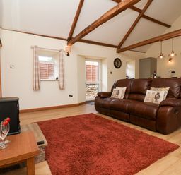 A living room with a sofa and coffee table at Crabtree Cottage in Suffield near Scalby