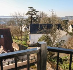 A view from a balcony showing houses and trees at Cambrie in Tenby