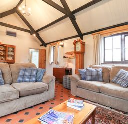 A living room with two sofas and blue patterned cushions at Bwthyn Alarch in Trefin St Davids Pembrokeshire