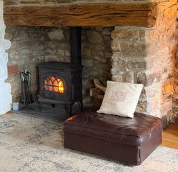 A living room with a fireplace and a seating area at Stable Cottage Newport, Pembrokeshire