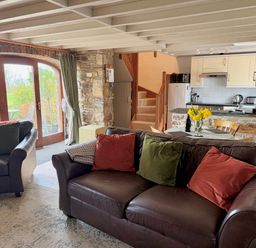 A living room with a sofa and armchairs at Stable Cottage in Newport, Pembrokeshire