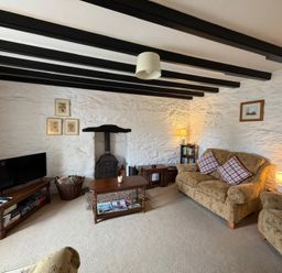 A snug with a television and a fireplace at Derlwyn Newport, Pembrokeshire