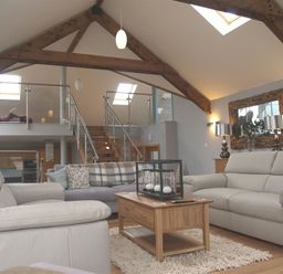 A living room with sofas coffee table and wooden beams in Seabrook Broad Haven Pembrokeshire