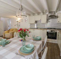 A kitchen with a dining table and stove at End Cottage in Newport, Pembrokeshire