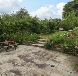 A garden with a table and benches in Brynawelon Newport, Pembrokeshire