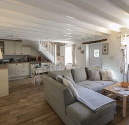 A living room with a sofa and dining area at Middle Cottage in Newport, Pembrokeshire