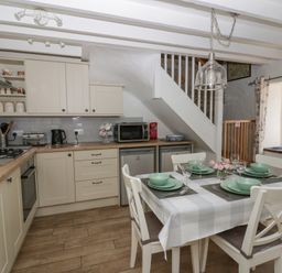 A kitchen with dining table and appliances at Middle Cottage in Newport, Pembrokeshire