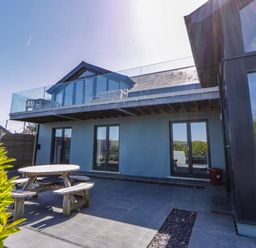 An outdoor area with a table and chairs beside a house at The Willows in Newport, Pembrokeshire
