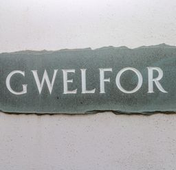A stone plaque with the word gwelfor on a white wall at Gwelfor Marloes