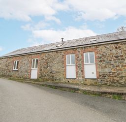 A stone building with windows and a door at Y Felin in Cardigan, Ceredigion