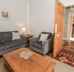 A living room with sofa and table at Dewi Villa Aberarth, Ceredigion