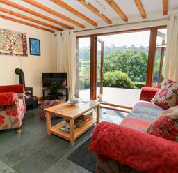A living room with sofas and a television at Dan Castell Cottage, Llandeilo, Carmarthenshire