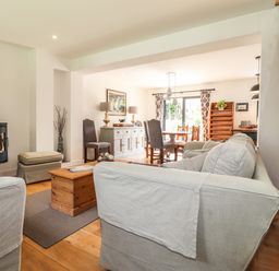 A living room with sofas a wooden coffee table dining table and chairs at Ty Cerrig in Newport Pembrokeshire