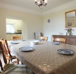 A dining room with a table covered in polka dot tablecloth and plates at Tremynydd Fawr in St Davids Pembrokeshire