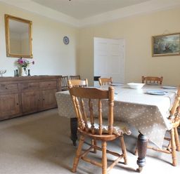 A dining room with a table covered by a polka dot tablecloth and wooden chairs around at Tremynydd Fawr in St Davids Pembrokeshire