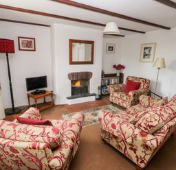 A living room with furniture and a fireplace at Ty Canol in Mathry, Pembrokeshire