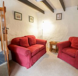 A living room with red sofas and a coffee table at Panteg, Cardigan Llangoedmor Cardigan
