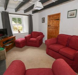 A living room with red sofas and a television at Panteg, Cardigan Llangoedmor Cardigan
