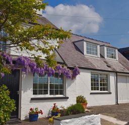 A house with purple flowers and windows at Beach Retreat in Aberporth