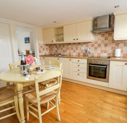 A kitchen with a table and chairs at Beach Retreat in Aberporth