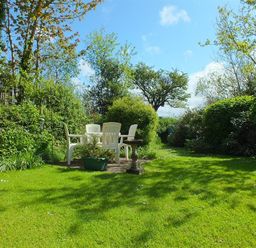 A garden with plastic chairs around a table and a bird bath at Granston Cottage in Castlemorris Pembrokeshire