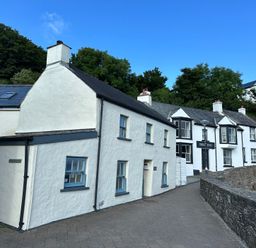 A cottage with a sign at the Swan Inn in Little Haven, Pembrokeshire