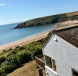 View of a beach and ocean near a house at Beach Cove, Freshwater East, Pembrokeshire
