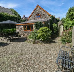 A garden with a table and chairs at Barn Court Cottage in Narberth, Pembrokeshire