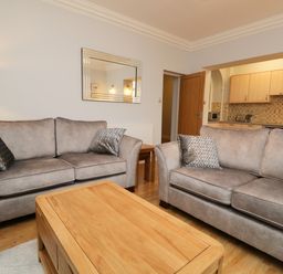 A living room with two gray sofas and a wooden coffee table at Tethera in Bowness-On-Windermere