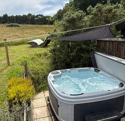 An outdoor area with a hot tub and a hammock at Deer Lodge in Wimborne Minster